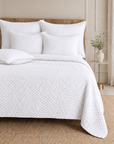 Quilted white bedding set with textured duvet cover and two square shams