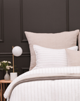 Natural big lumbar pillow set on bed with visible woven cover and square shape