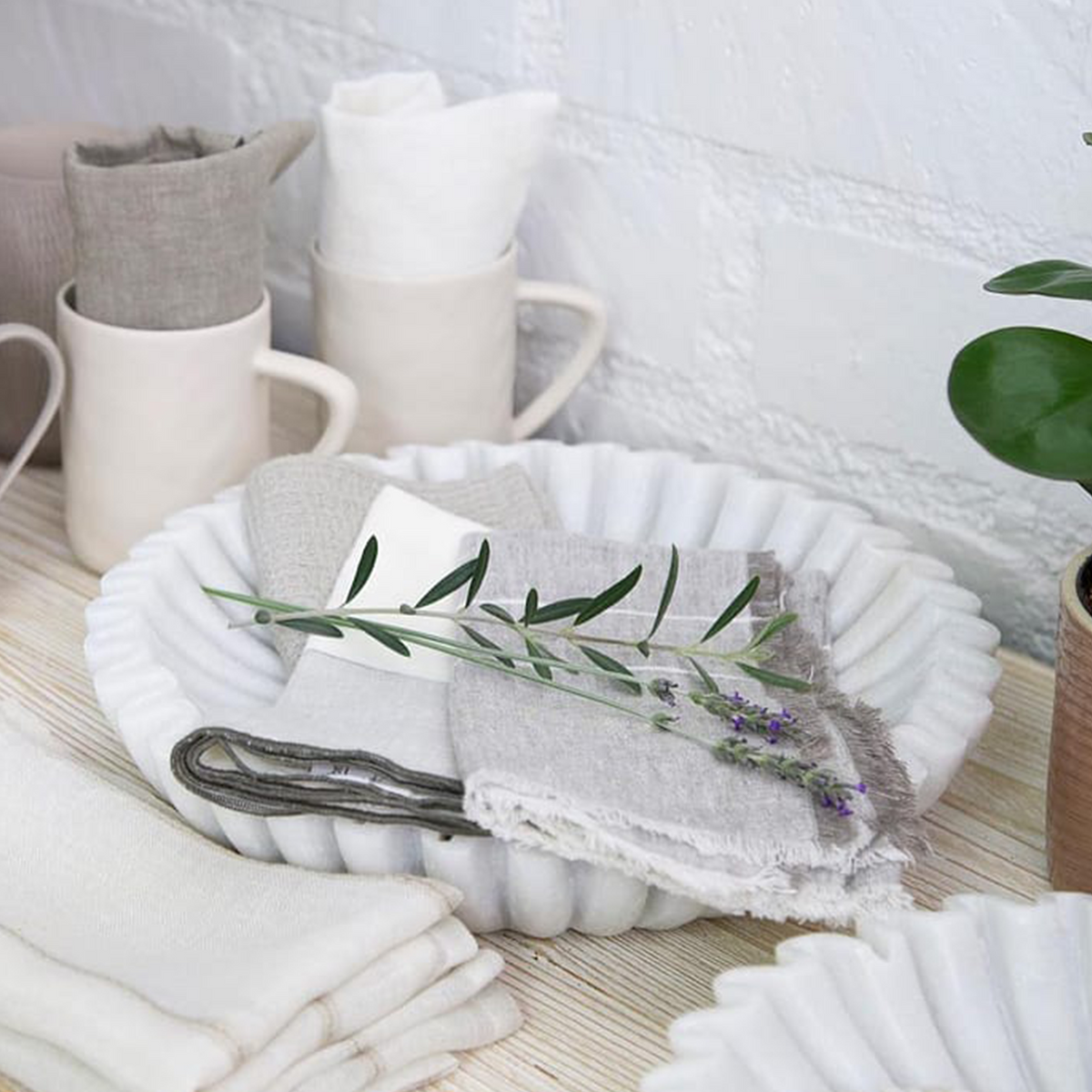 Napkin bundle with white and gray two-tone fabric and a floral sprig on top