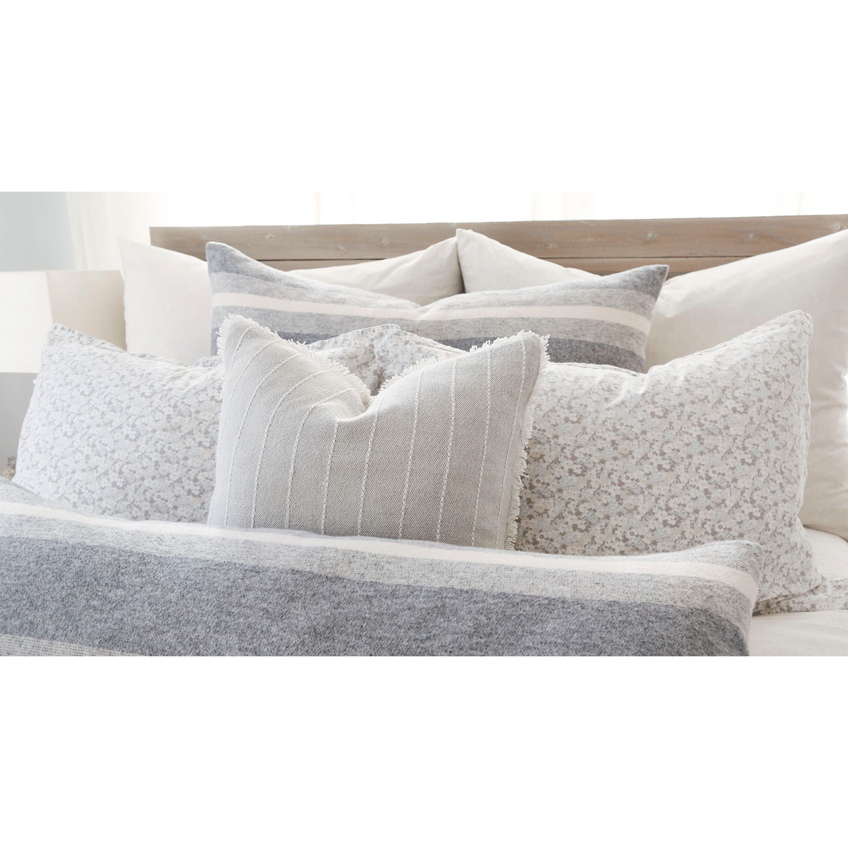 Square big pillow with light gray floral print cover with insert, on bed