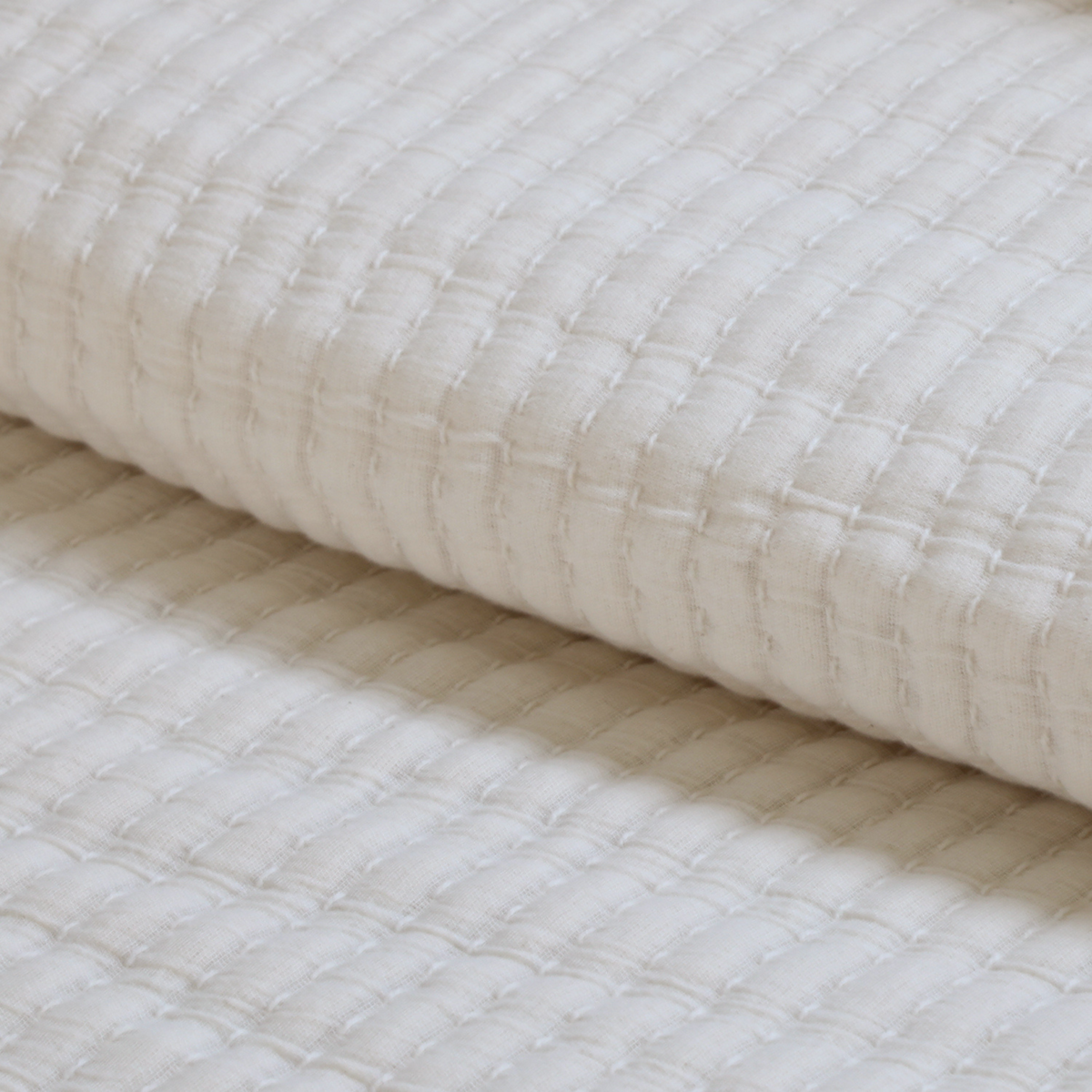 Vancouver coverlet in cream with woven grid and raised loop stitches, close-up