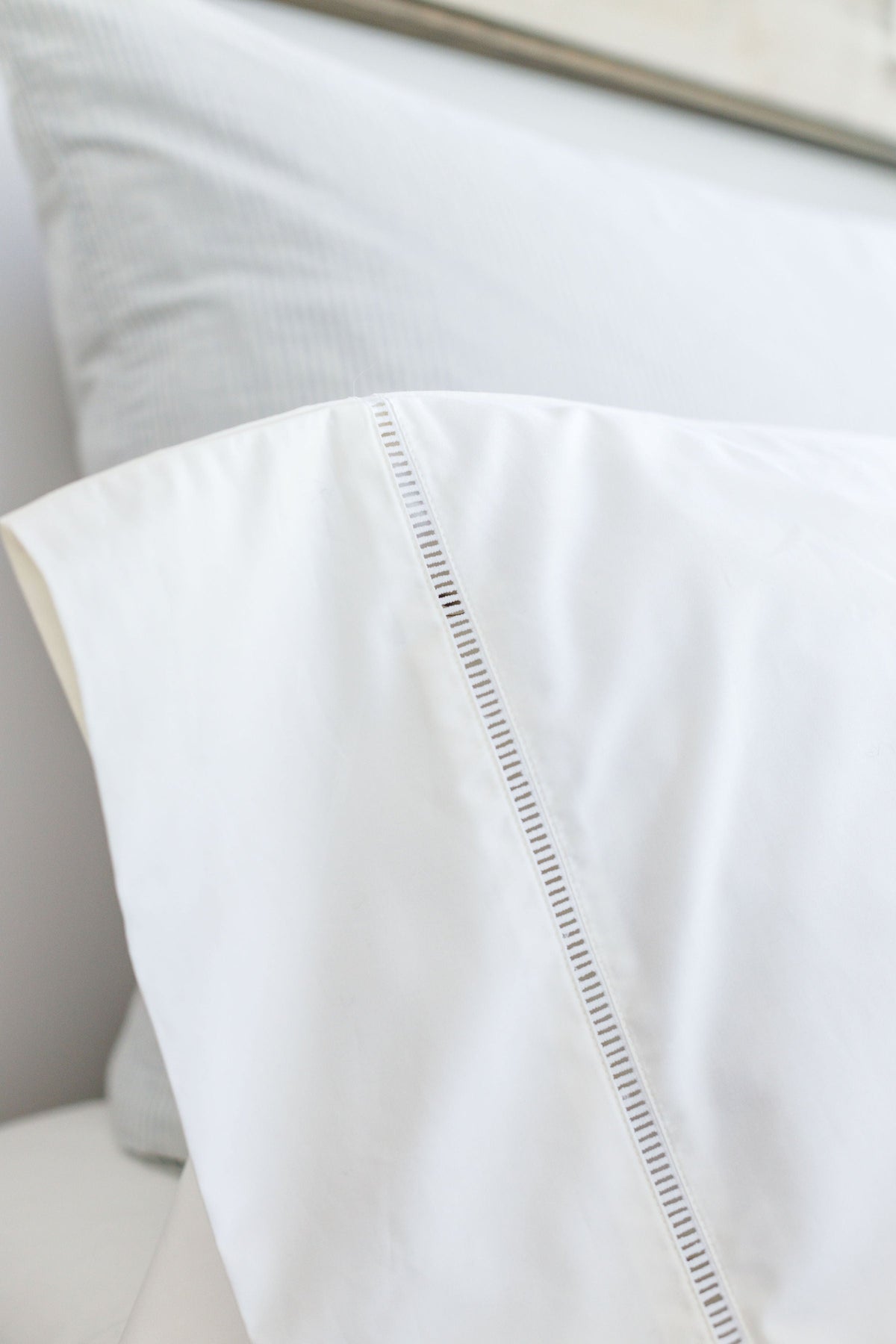 White pillowcase with ladder-stitched diagonal trim along the front