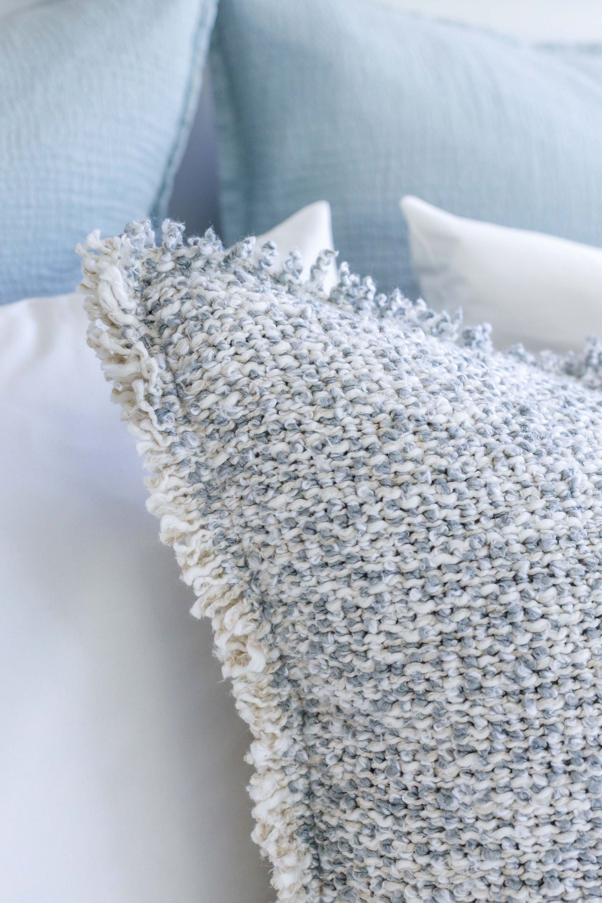20x20 textured pillow with insert, close-up light gray knit with fringe border and tassel.