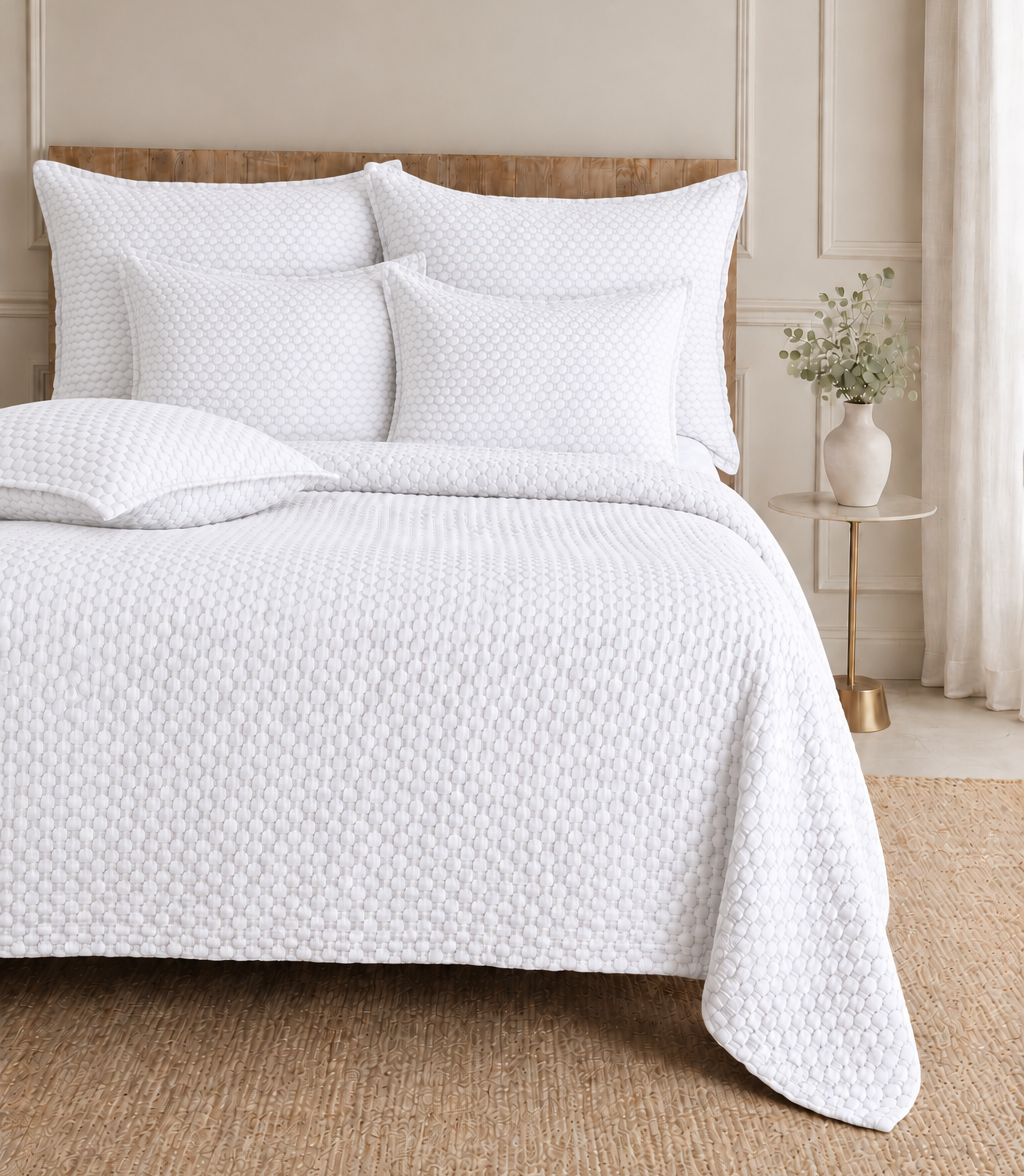 Quilted white bedding set with textured duvet cover and two square shams