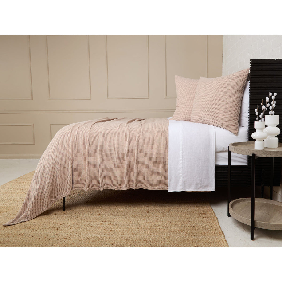 Ivory textured blanket with pleated drape over bed, styled with matching pillows.