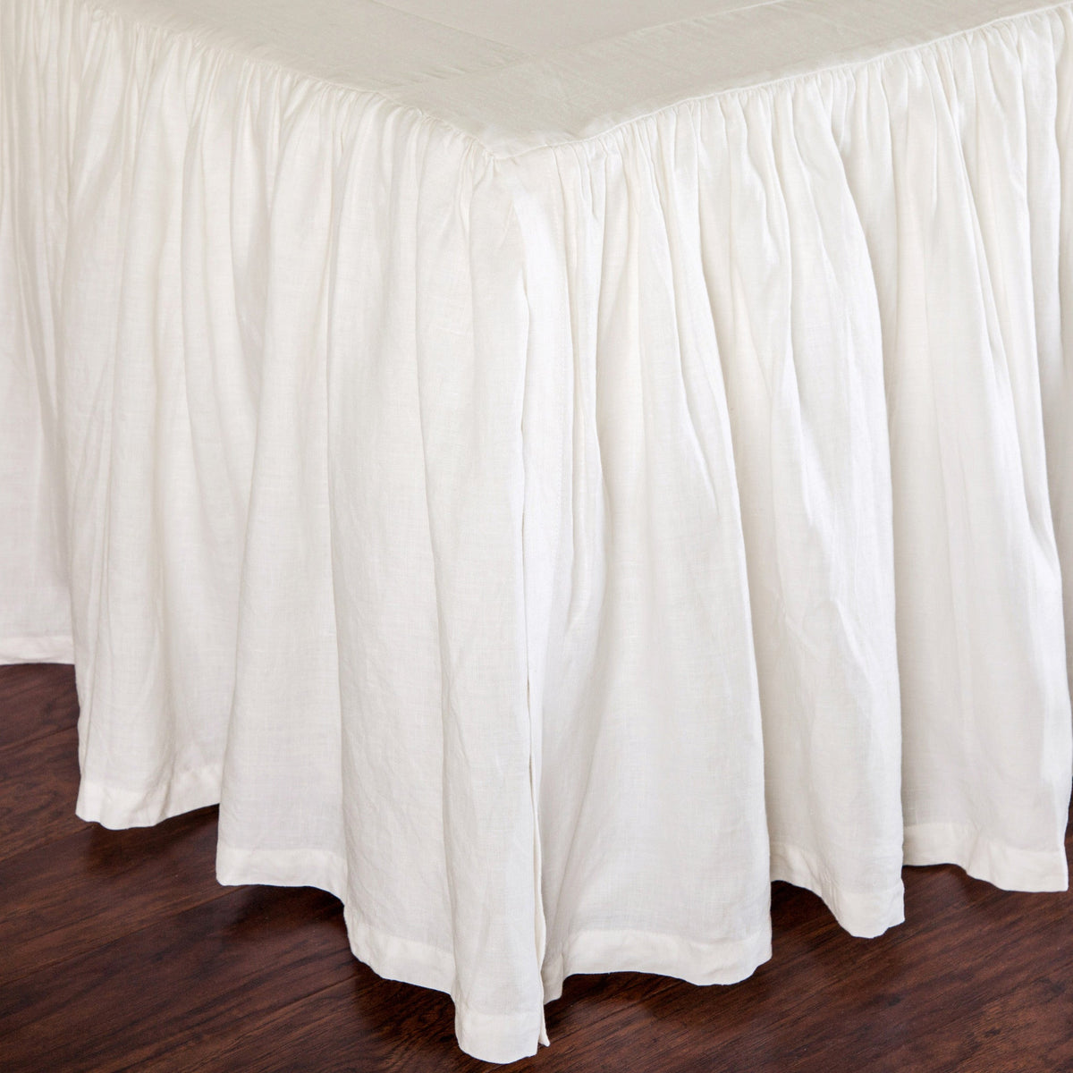 White gathered linen bedskirt with full, fluted ruffle panel and straight edge