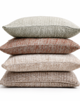 Stack of rectangular decorative pillows: light gray-green, rust, and beige textured covers