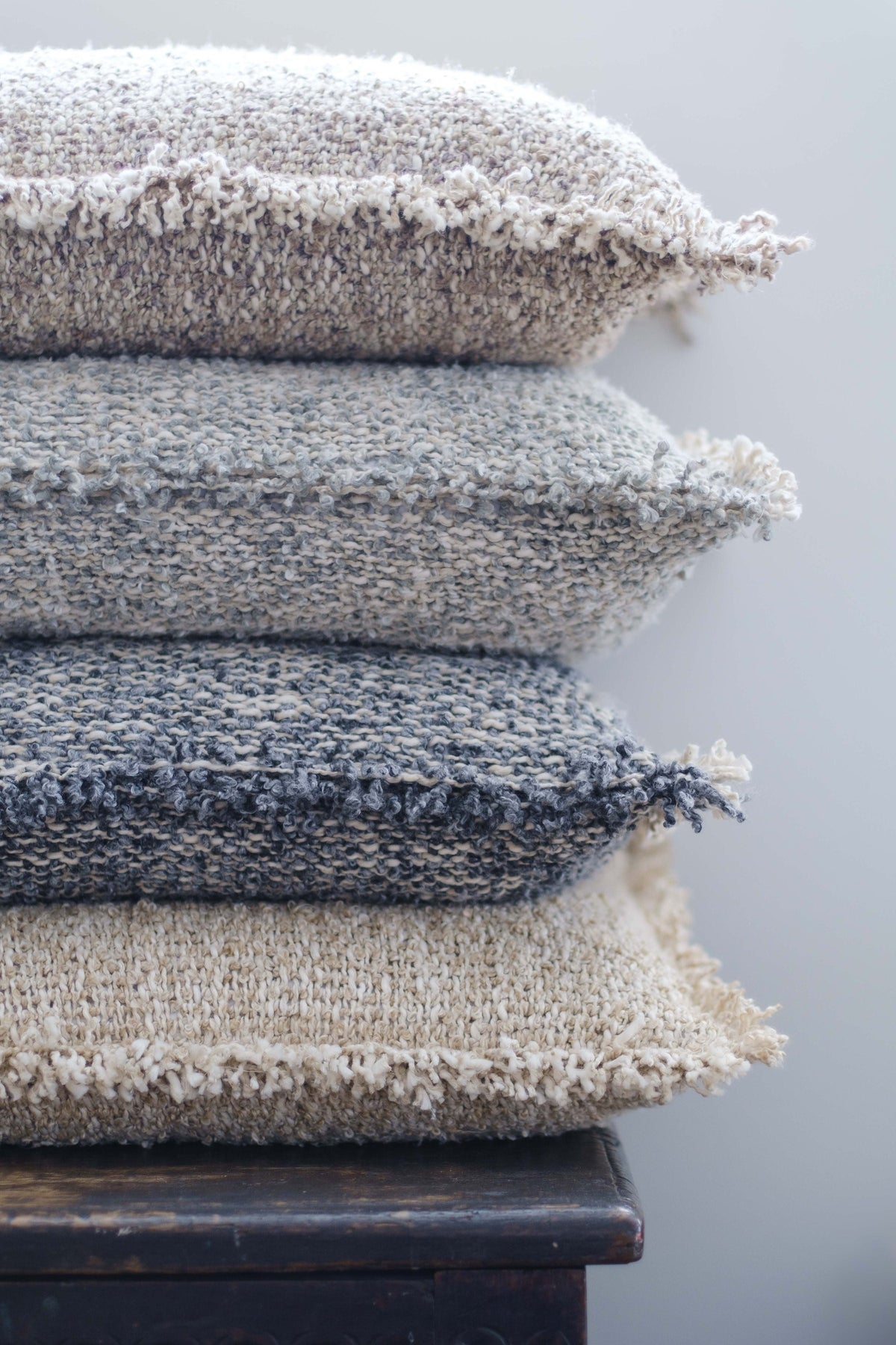 Textured 14x24 pillows with fringe trim, stacked in light beige, gray-blue, and navy