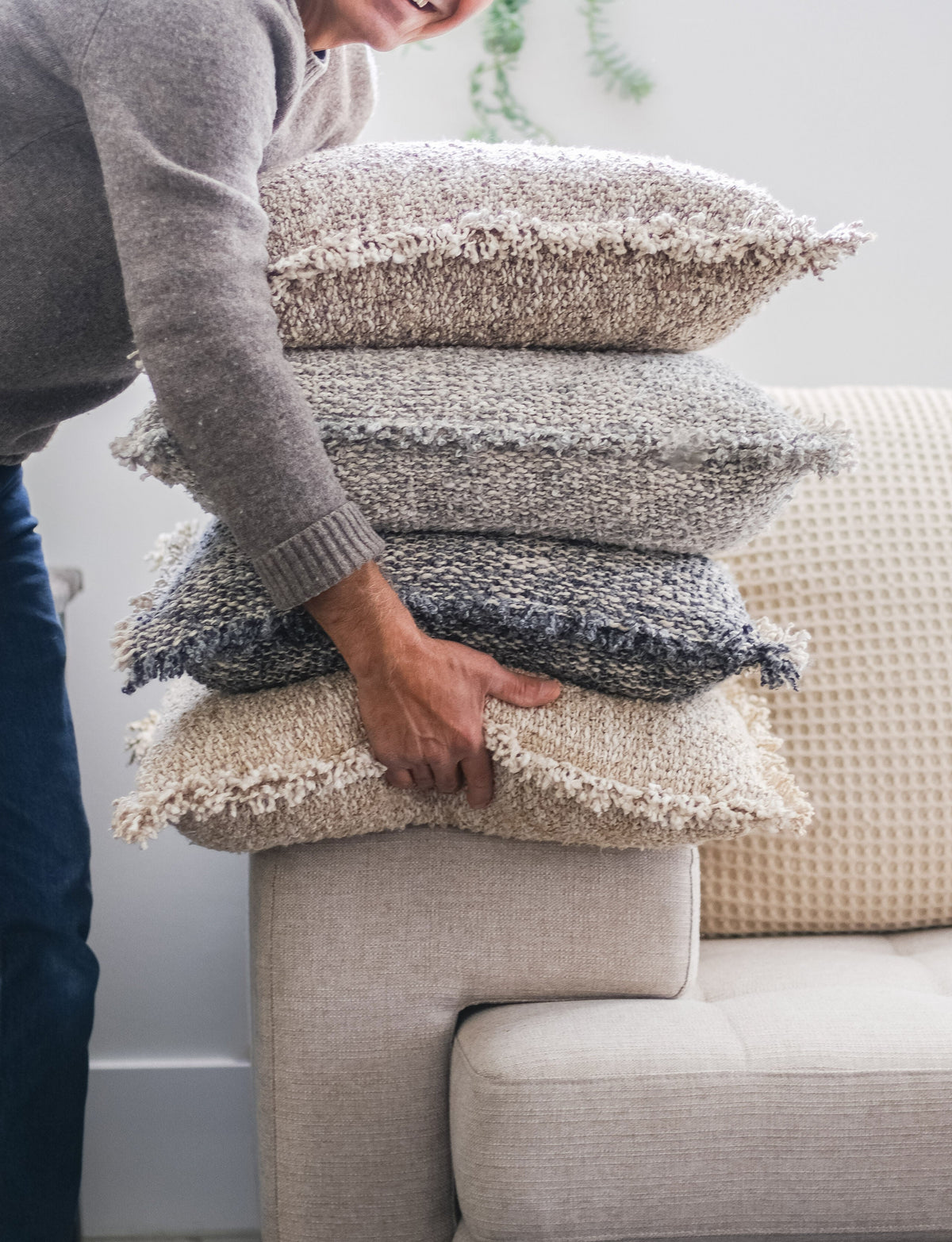 20x20 textured pillow with insert, dark gray tones, stacked on couch with fringed edges.