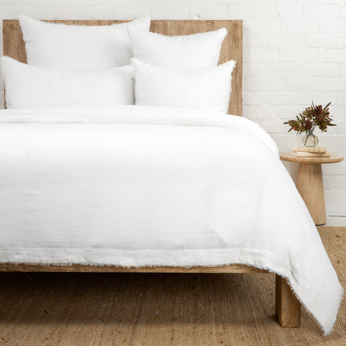 White duvet cover with matching pillow shams, textured fabric and frayed edges