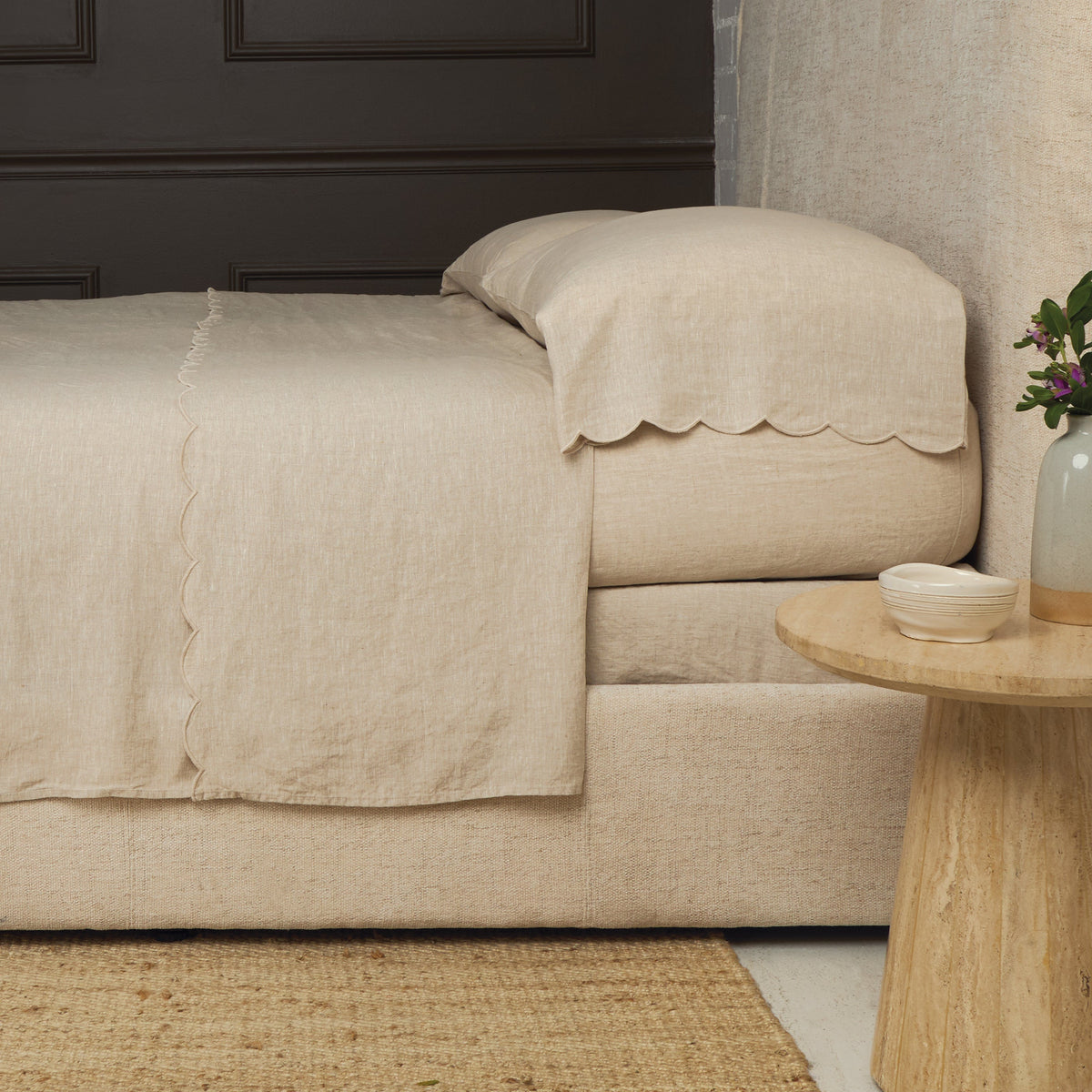 Cream linen sheet set with terracotta scalloped edge trim on pillows