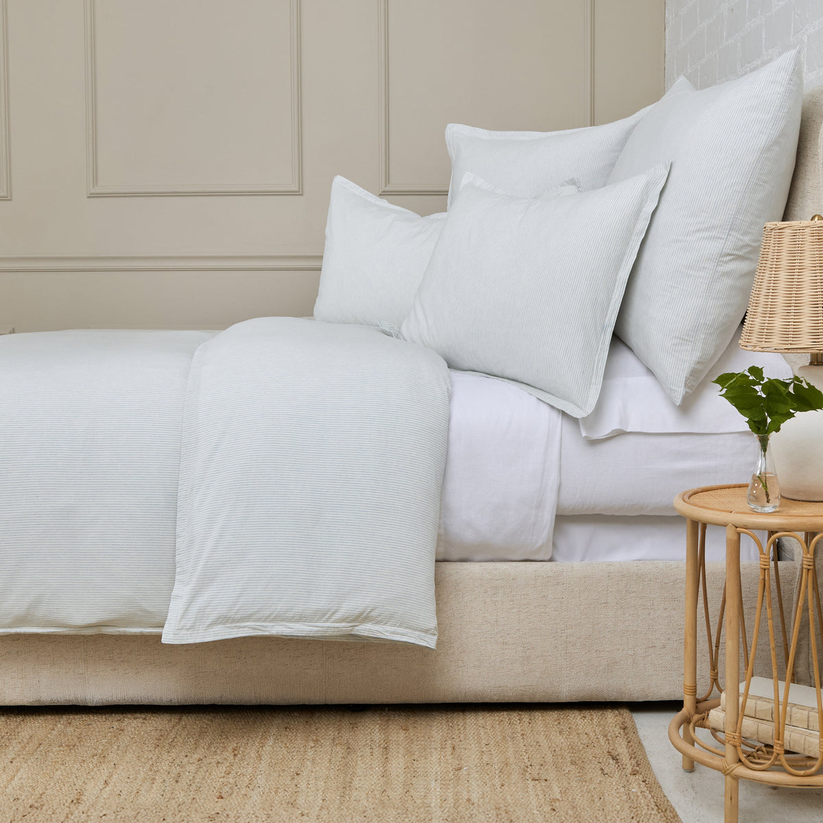 Natural duvet cover with soft off-white fabric and stacked decorative pillows