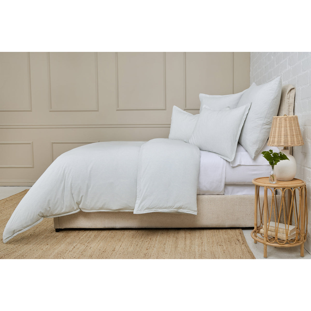 Light blue duvet cover set with two shams and duvet on a bed