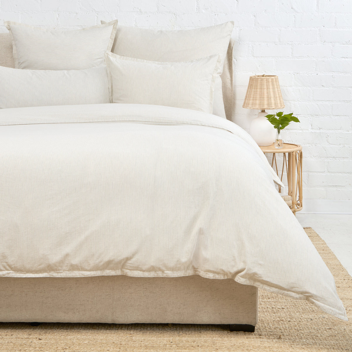Natural duvet cover with two shams on a bed, off-white fabric