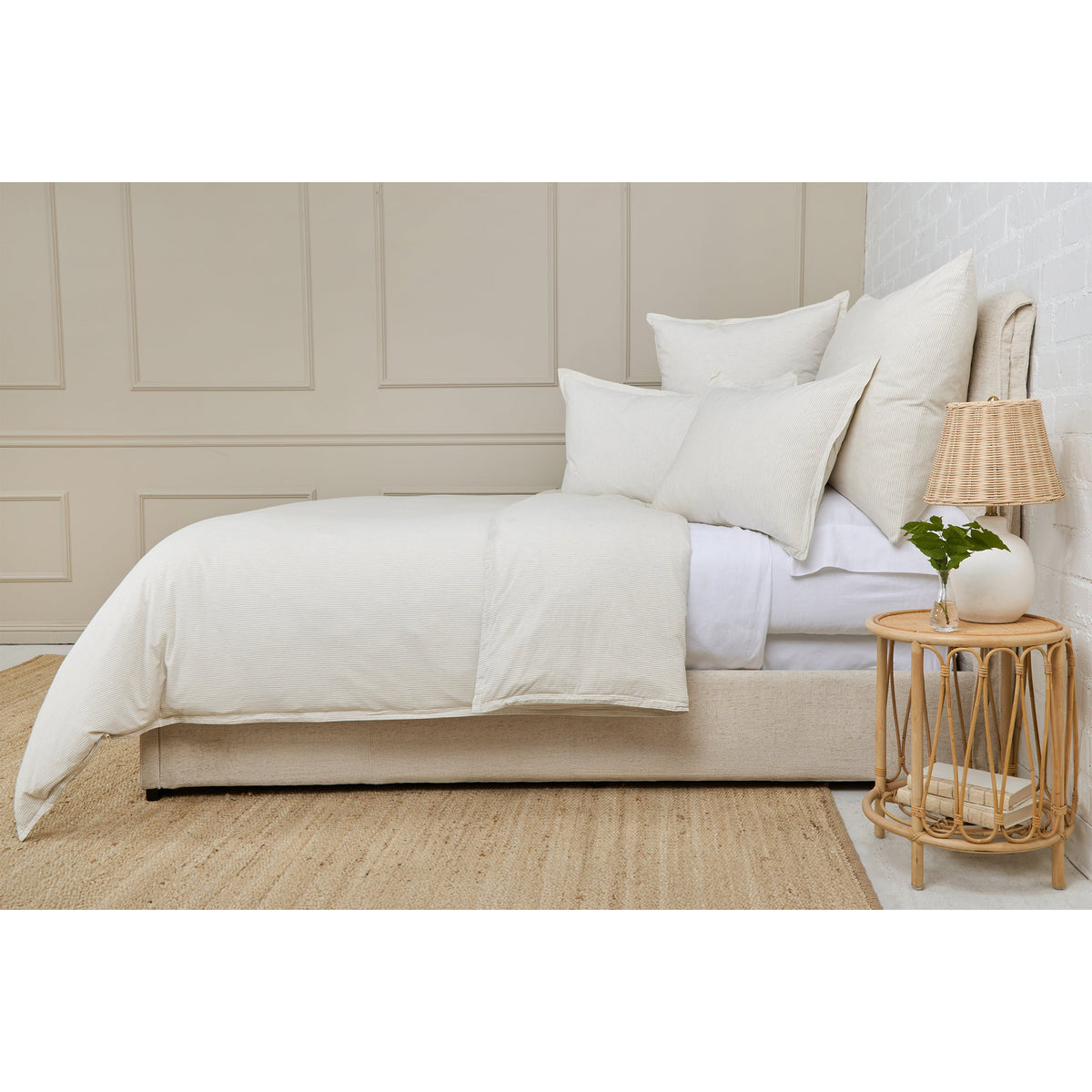 Light blue striped duvet cover on bed with two matching shams