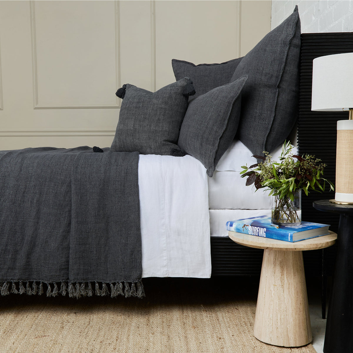 Charcoal textured blanket with fringed edge and matching dark pillows