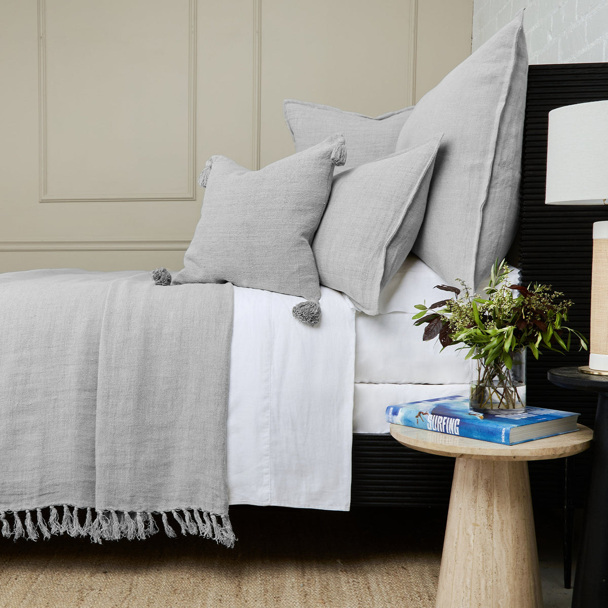 Montauk blanket, light gray woven throw with fringed edge on bed