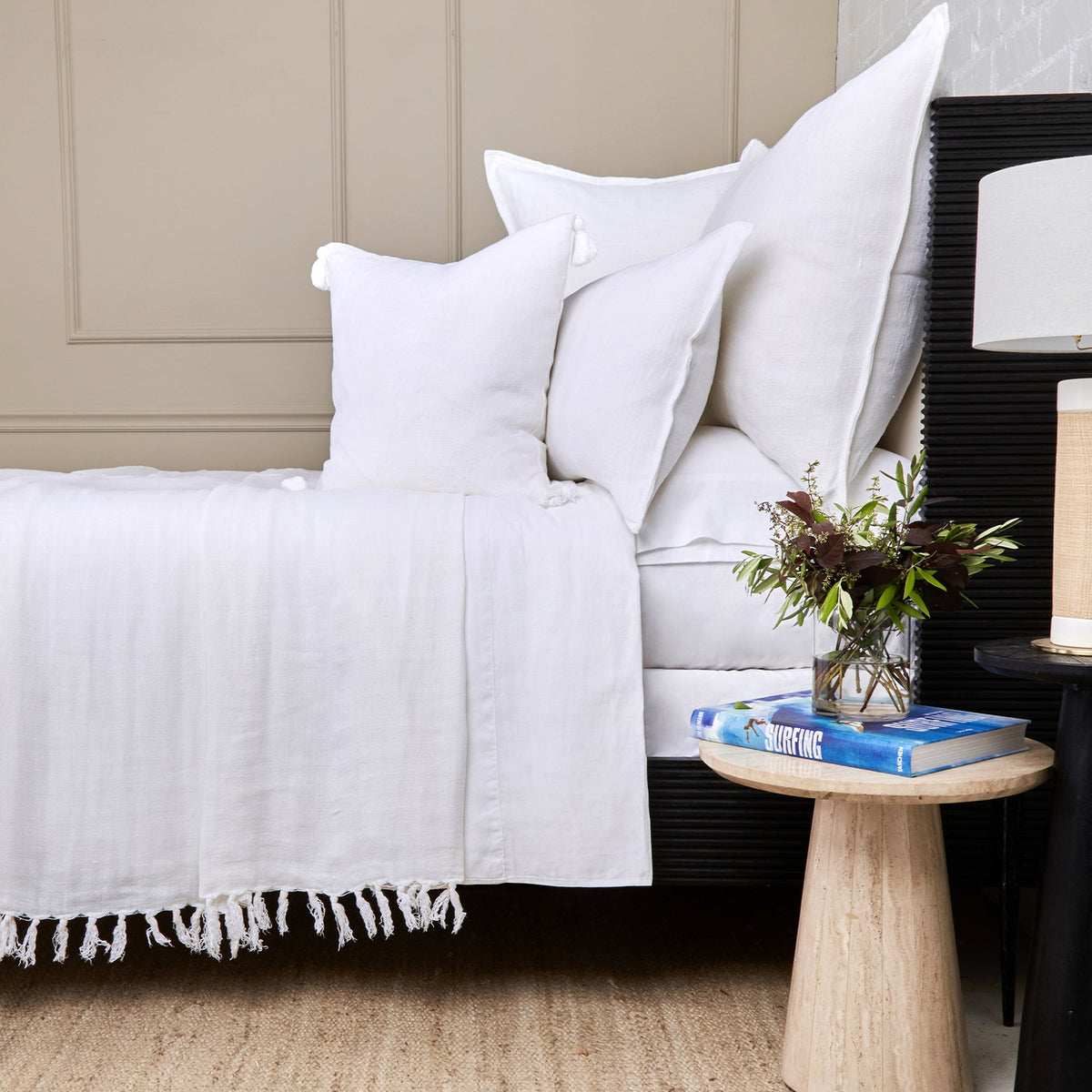 White textured blanket with fringed edge and large white pillows