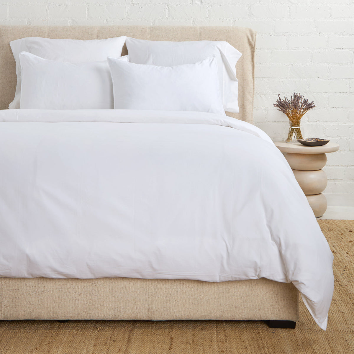 White cotton sateen duvet cover set with pillow shams, neatly tucked corners
