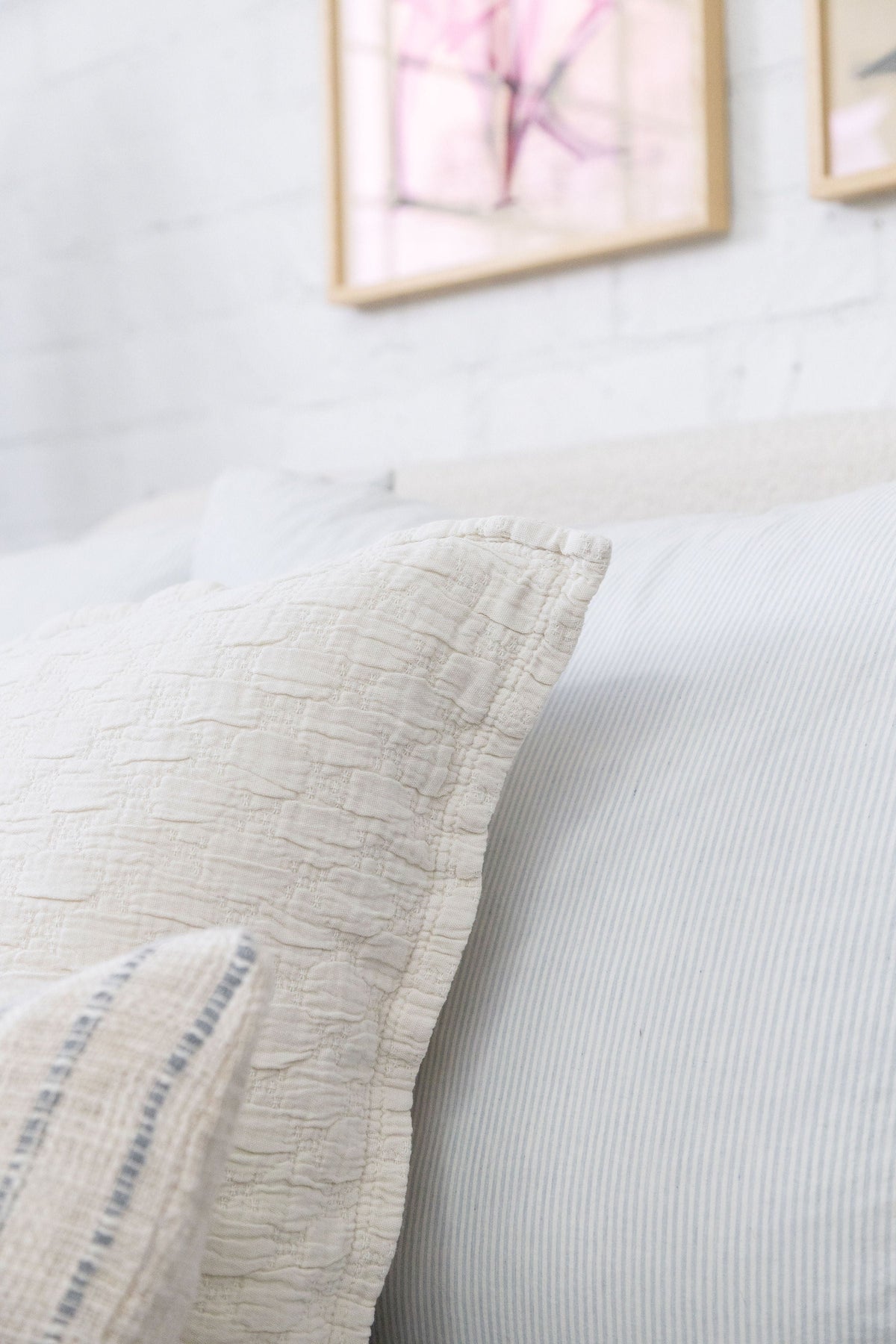 Light matelasse pillow with subtle woven texture and stitched edge detail