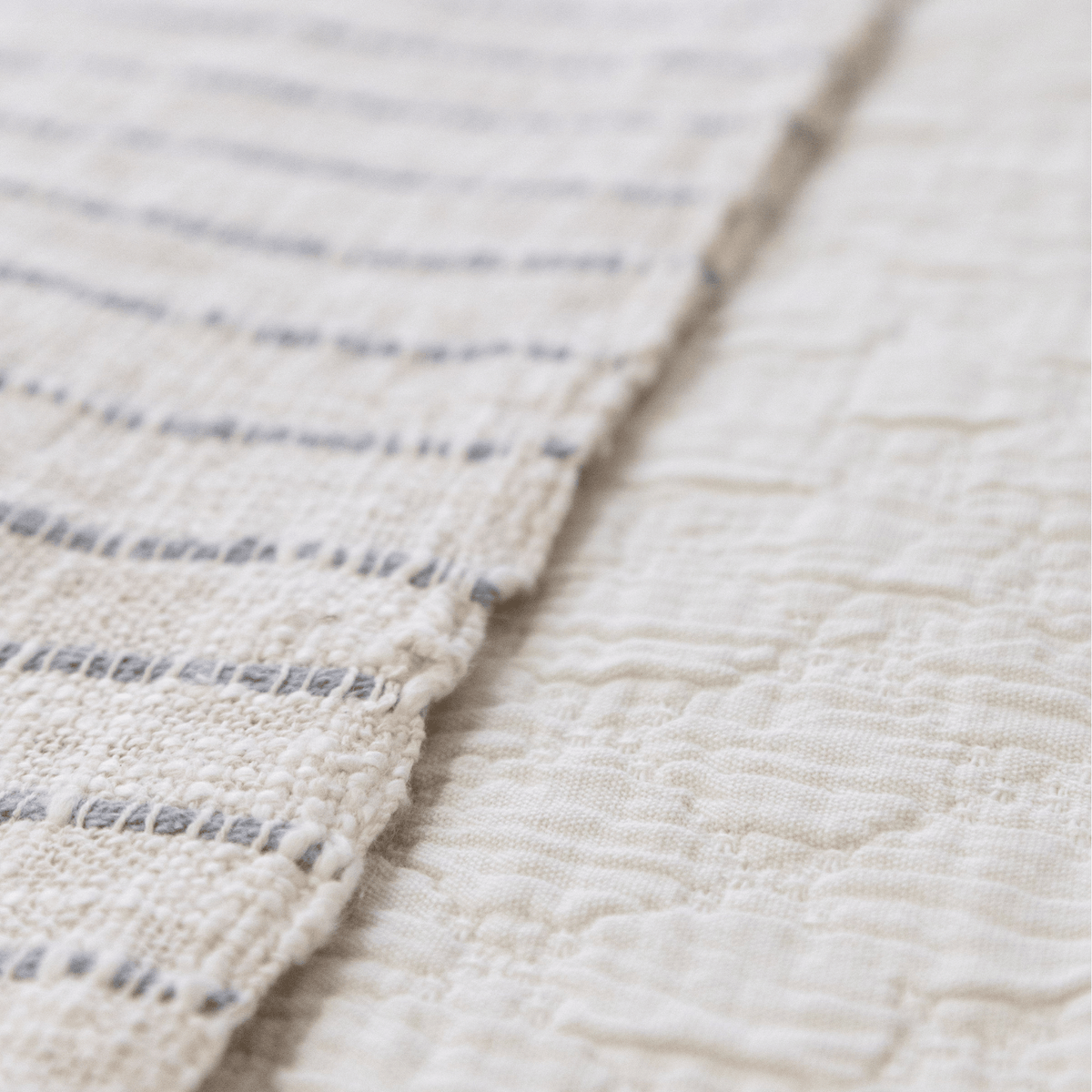 Light matelasse quilt with stitched channels and fringe trim along the edge