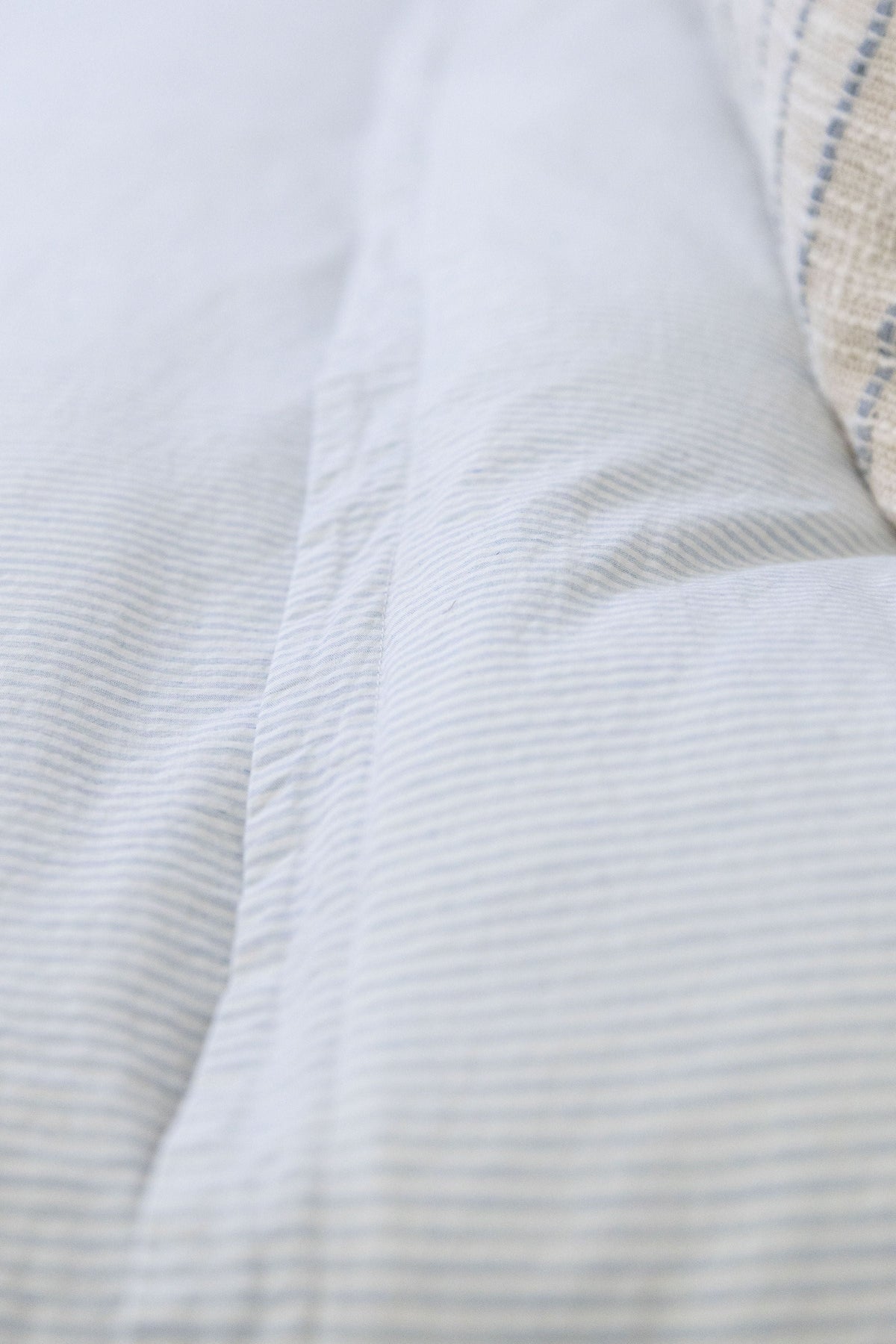 Luke duvet cover close-up of white pinstripe fabric seam and fold