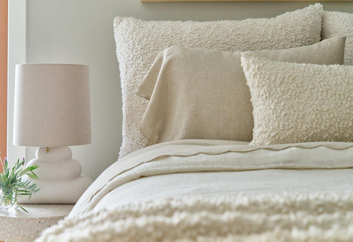 28x36 textured boucle accent pillow with insert, cream on bed