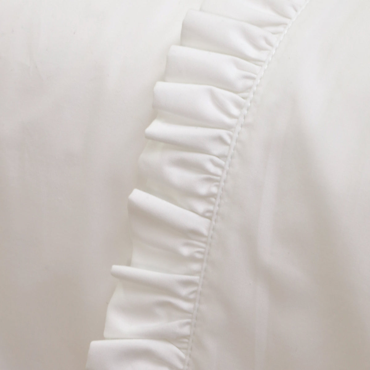 White cotton percale flat sheet with gathered ruffle trim along the edge