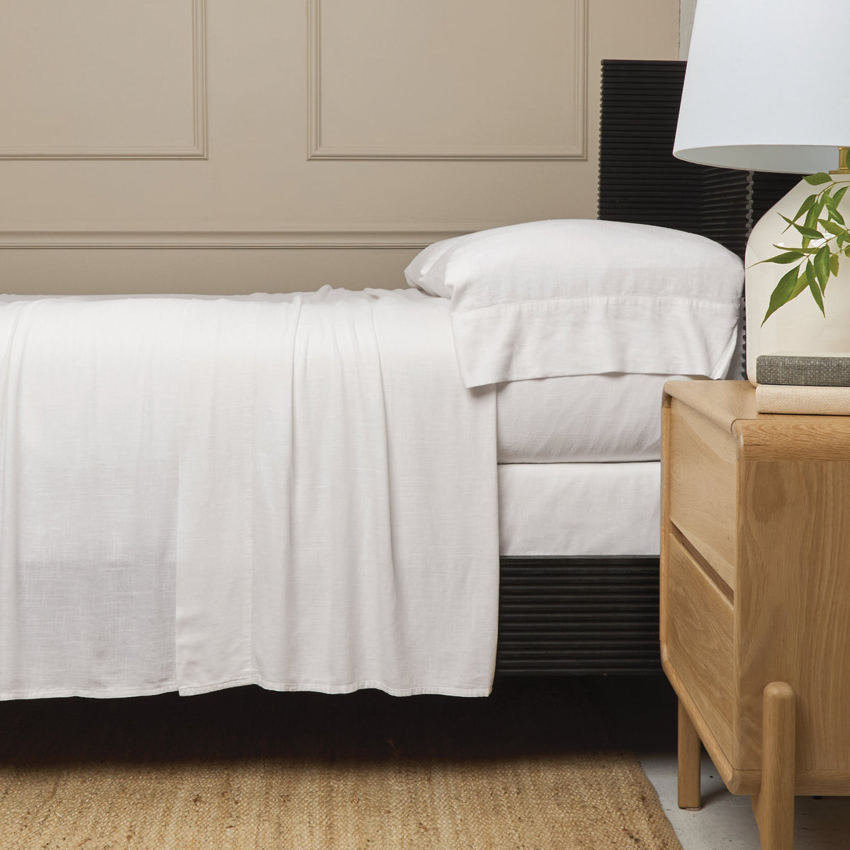 White bamboo linen sheet set with fitted and flat sheets and standard pillowcases on bed.