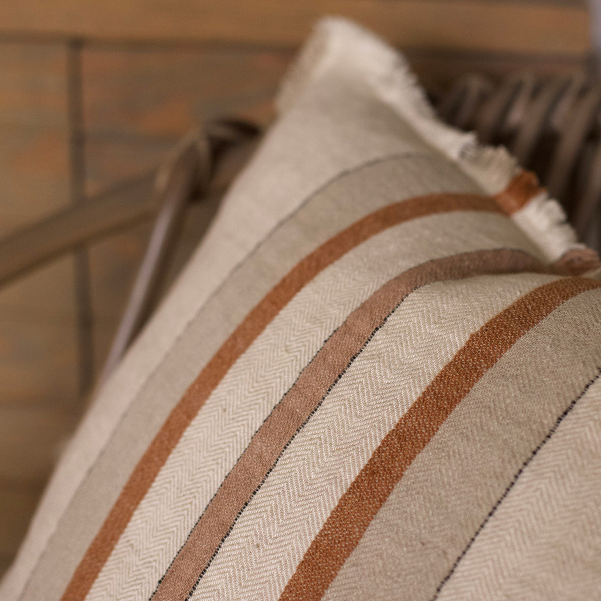 Cream pillow cover detail with vertical textured stripes in brown and rust