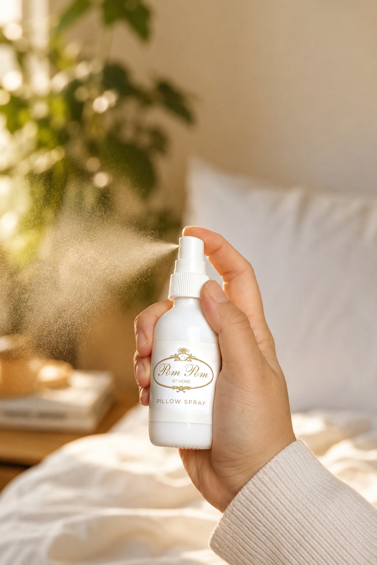 Hand holding Pom Pom at Home pillow spray bottle with pump sprayer