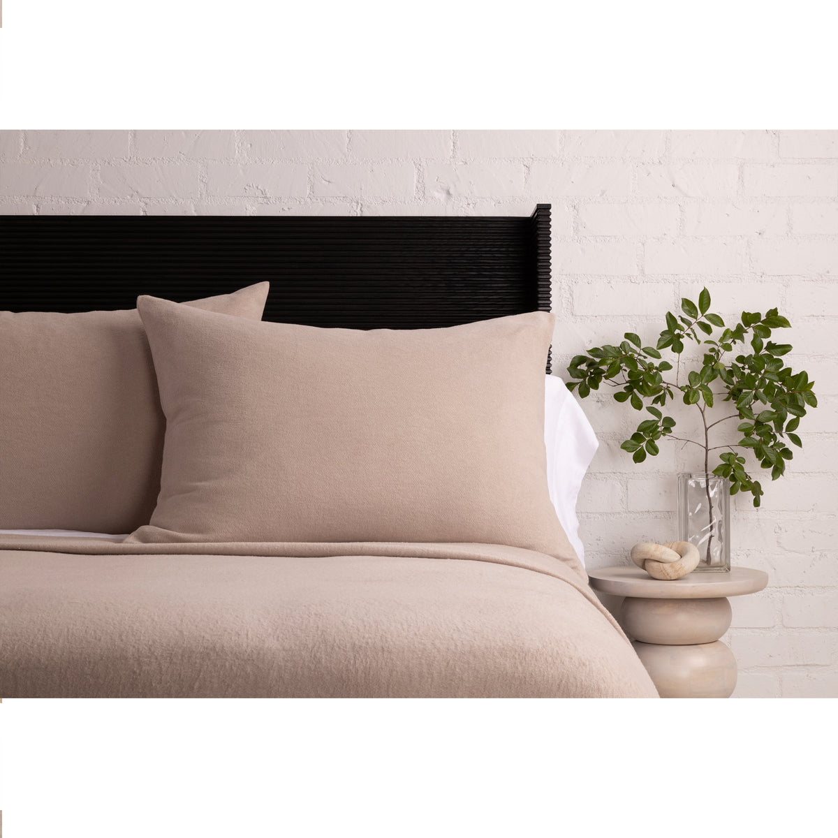 Taupe blanket and pillow styled on a bed