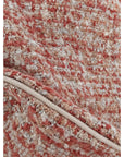 Close-up of rust orange textured woven pillow fabric and side seam