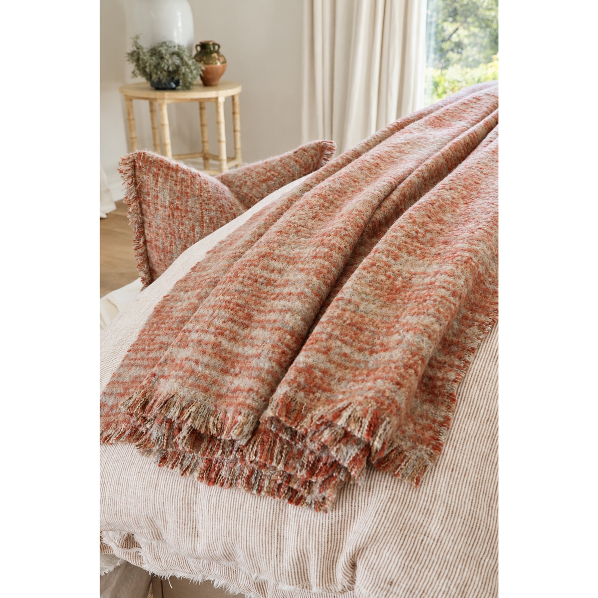 Oversized throw blanket in rust orange with textured weave and fringed ends.