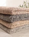 Brentwood woven throw blanket stack in natural, pebble and ocean tones, folded neatly
