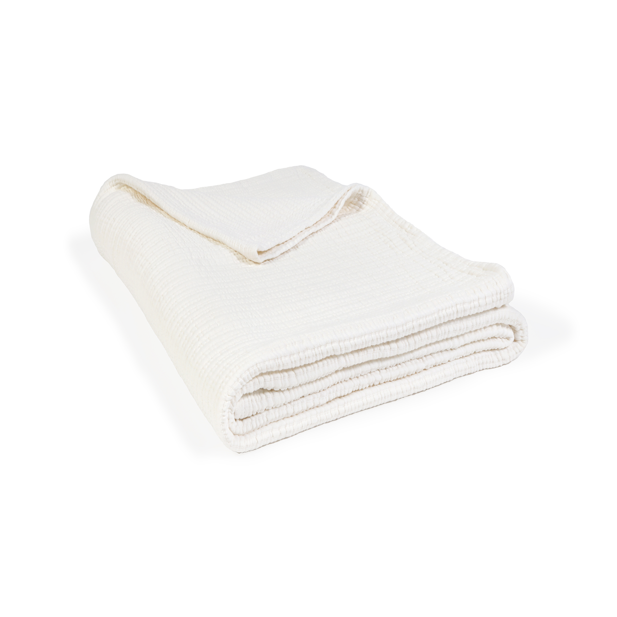 Oversized throw blanket in cream folded with textured weave and neat hem on a white background.