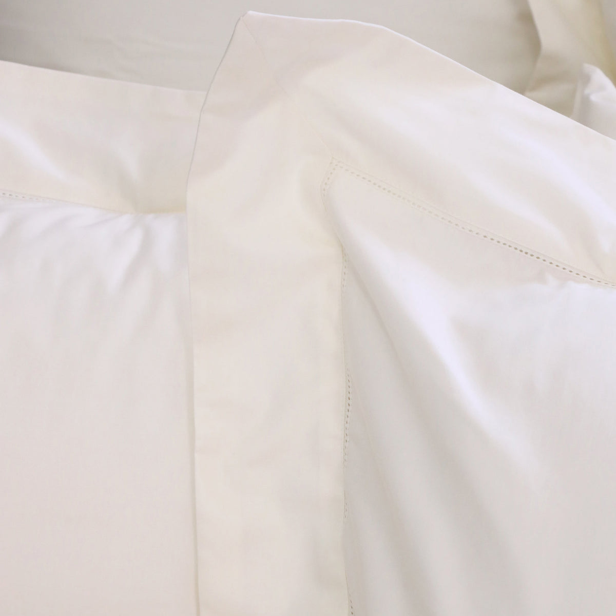 Close-up of white cotton sateen duvet cover with decorative stitched panel