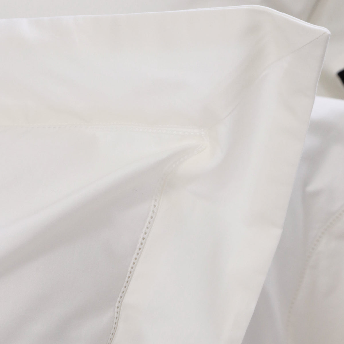 White cotton sateen duvet cover corner with smooth fabric and stitched seam