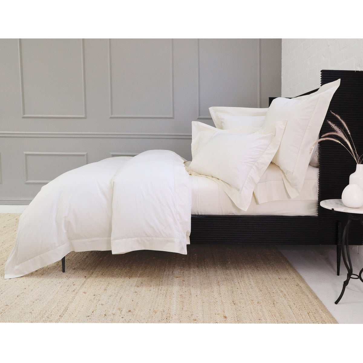 White cotton sateen duvet cover set with folded duvet and matching shams on bed