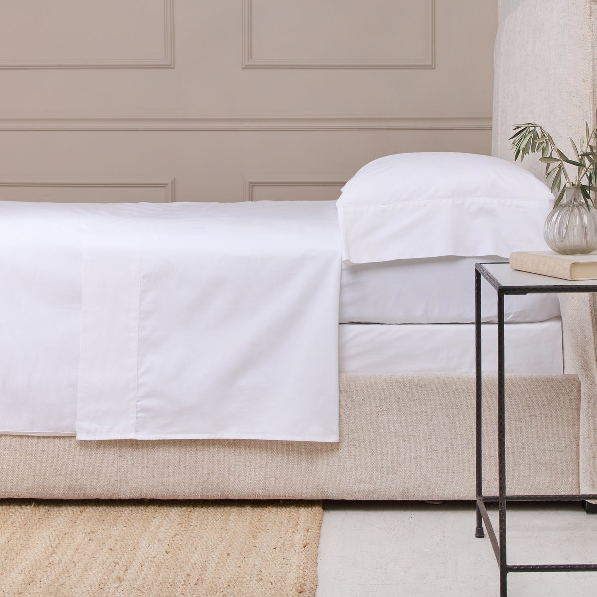White cotton sateen sheet set: fitted and flat sheets with pillowcase on bed