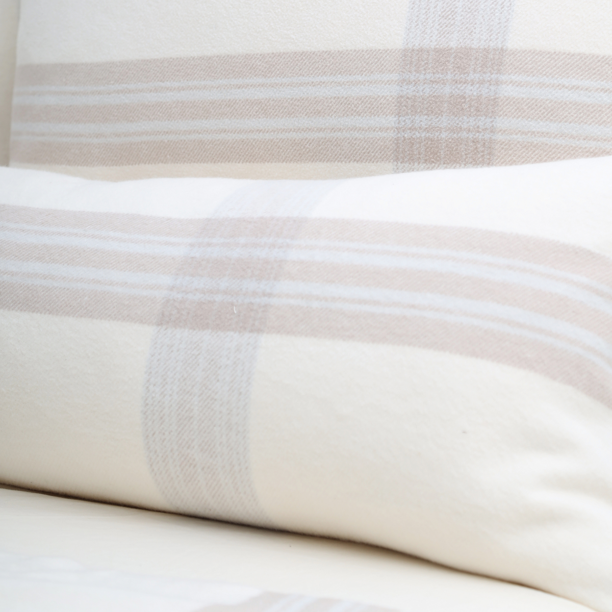 Geneva blanket close-up: white fabric with beige plaid stripes running horizontally