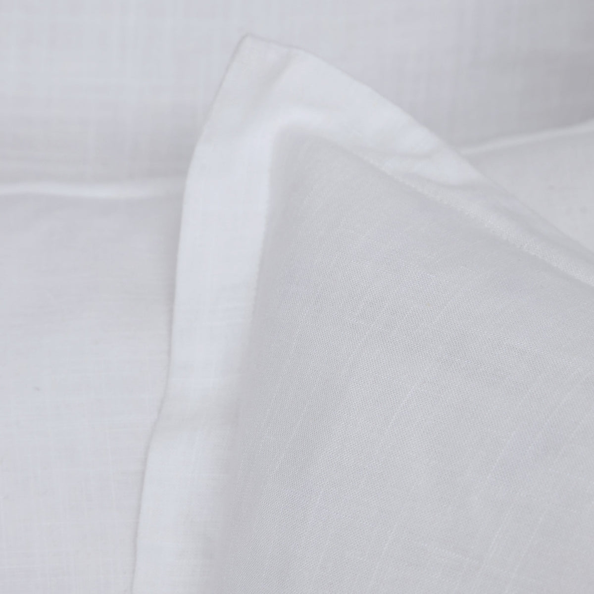 White bamboo-linen pillow close-up with textured weave and corner seam