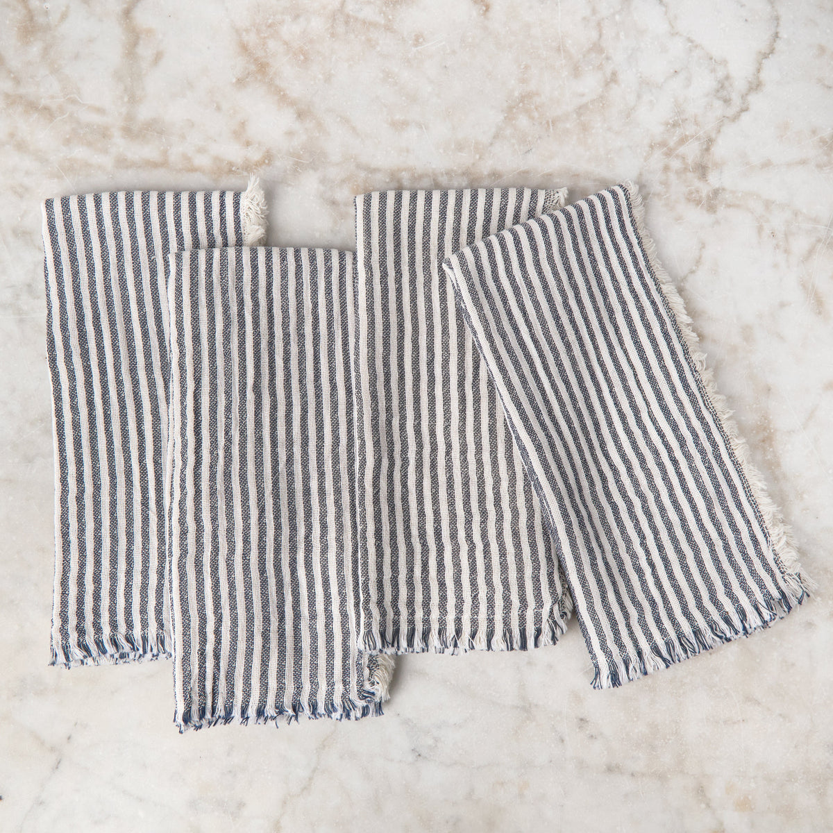 Charcoal striped napkin set with fringed edges, folded in three pieces