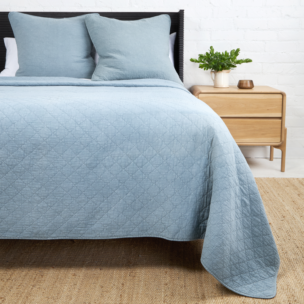 Dusty blue Huntington coverlet with subtle diamond quilt pattern and overhang edge.