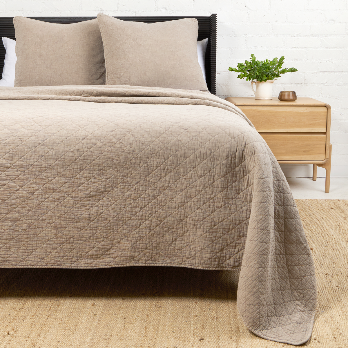 Taupe Huntington coverlet with diamond quilt texture and soft drape over bed edge.