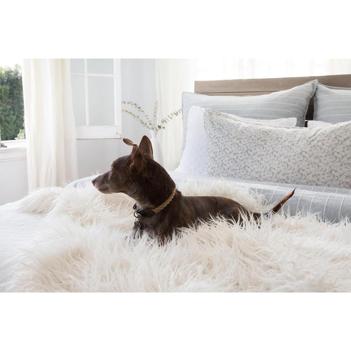Gray speckled body pillow with insert on bed, oblong lumbar shape