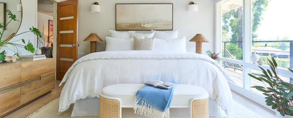 White Kelly duvet cover with scalloped trim and matching shams on a bed
