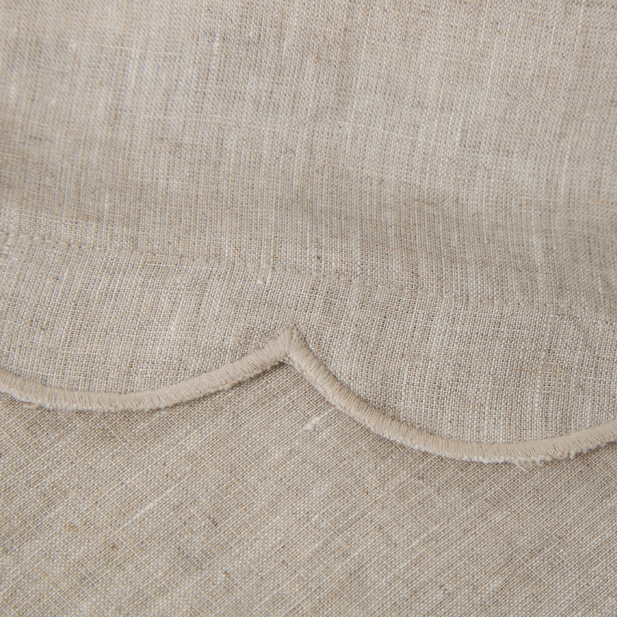 Cream linen sheet seam with scalloped edge and light trim border