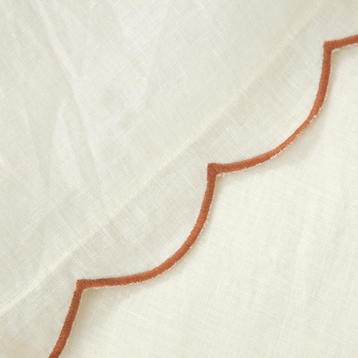 White fabric detail with terracotta (rust) scalloped piping trim
