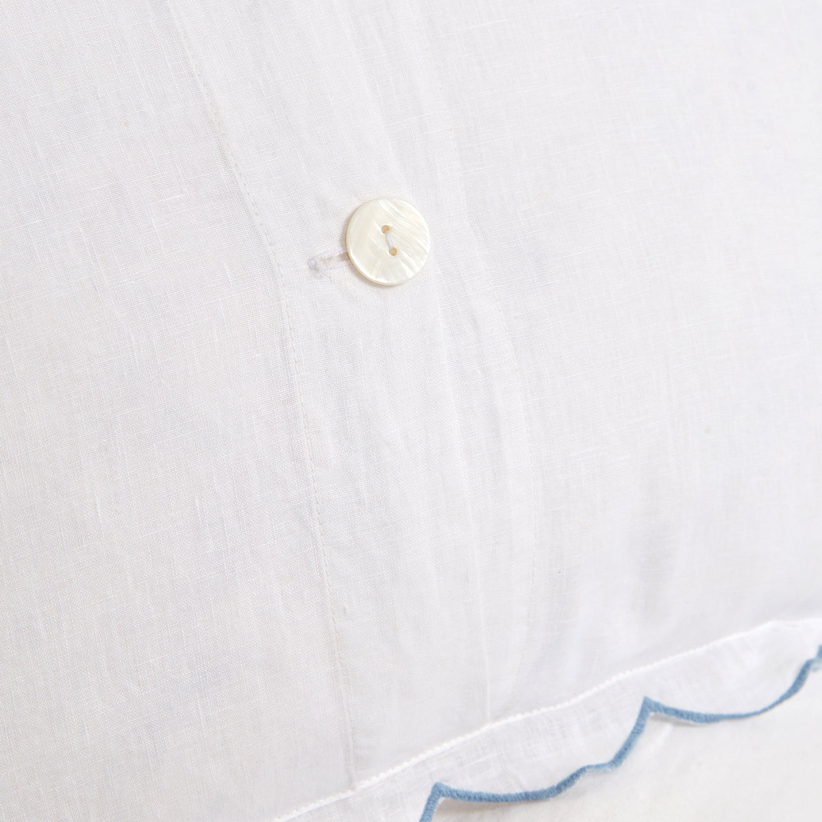 White duvet cover fabric detail with round button closure